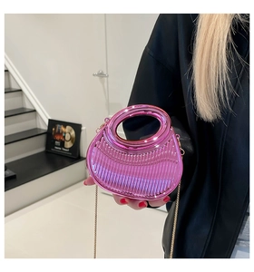 Détail du sac à main demi-lune rose métallisé avec texture verticale et chaîne dorée