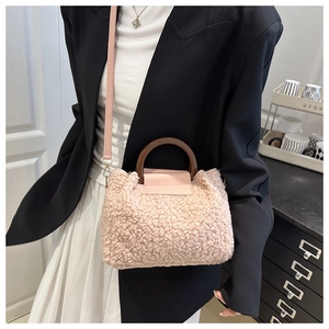 Détail du sac à main en laine d'agneau rose avec poignées rondes marron et bandoulière