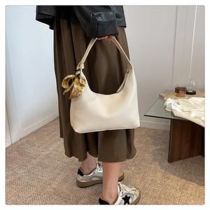Detail of cream hobo bag with vintage silk scarf on handle and lychee texture