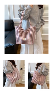 Close-up of red striped canvas tote bag with woven label and wide shoulder straps