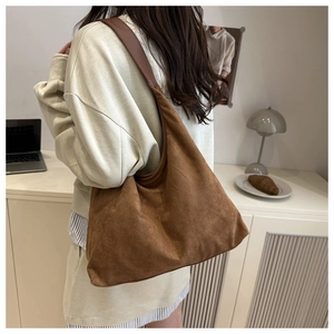 Minimalist vintage brown hobo bag in matte suede texture shown in a lifestyle setting