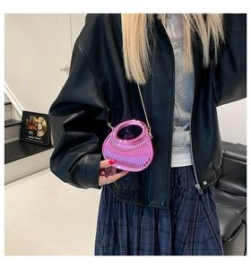 Close-up of bright pink acrylic crossbody bag with vertical texture and gold chain strap