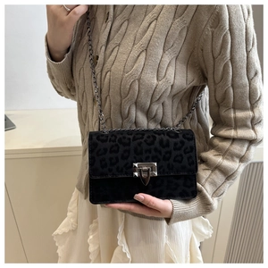 Detail of leopard print chain bag featuring a square metal clasp and velvet texture