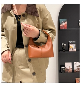 Detail of camel leather hobo bag featuring vertical stitching and dual top zipper