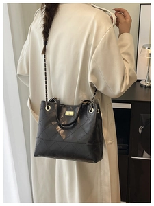 Détail du sac bandoulière noir matelassé avec chaîne dorée et fermoir pivotant élégant
