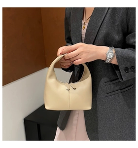 Detailed view of the beige hobo mini bag showing smooth leather texture and double zippers