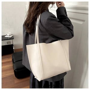 Close-up of minimalist white PU leather tote bag with long handles for shoulder carry