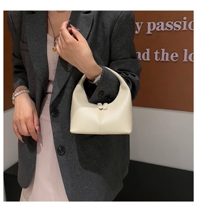 Minimalist cream white hobo handbag with central stitching shown on model shoulder