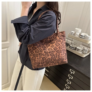 Side view of large leopard print canvas tote bag with shoulder strap in a home setting