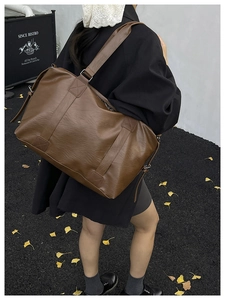 Detail of deep brown large tote bag with textured leather and silver hardware accents