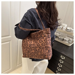 Detail of a large leopard print tote bag shown on model for a trendy casual look