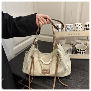 Detail of khaki tote bag with pearl chain decoration and double zippers on the side