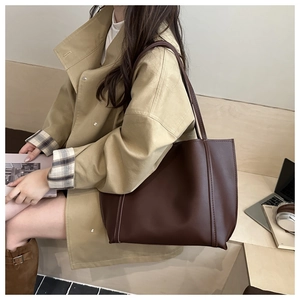 Close-up of a vintage dark chocolate tote bag featuring premium PU leather and fine stitching