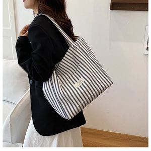 Blue and white striped canvas tote bag detail showing large capacity and decorative label
