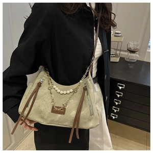 Détail du sac bandoulière vintage vert clair avec chaîne de perles et étiquette cuir