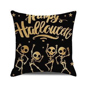 Detail of Happy Halloween pillow case featuring gold dancing skeletons on black fabric