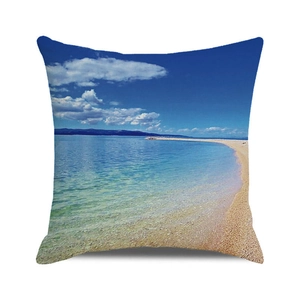 Detail of square cushion cover featuring summer beach photography with blue sea and sand