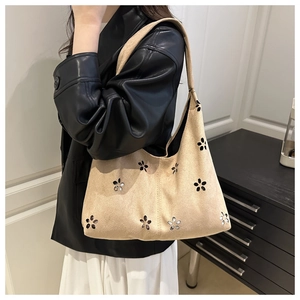 Détail du sac hobo en daim beige avec fleurs découpées au laser et paillettes brillantes