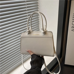 Elegant white crossbody handbag with knotted handles and Fashion Bag gold lettering