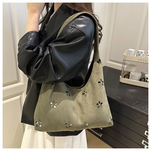 Close-up of moss green suede hobo bag featuring floral laser-cut patterns and soft texture