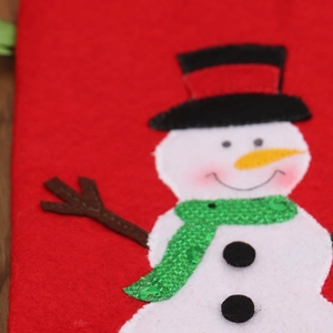 Close-up of Christmas felt wine cover featuring a sequined snowman with a carrot nose