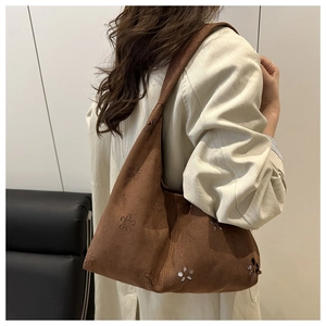 Détail du sac cabas en suédine marron avec motifs floraux ajourés au laser sur le côté