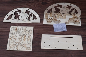 Flat lay view of DIY wooden Christmas nativity scene laser-cut parts on a wood background
