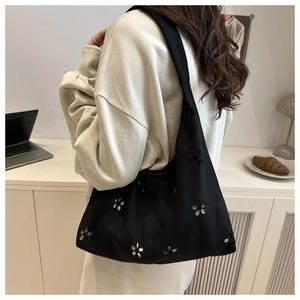 Nahaufnahme der schwarzen Hobo-Tasche aus Wildleder mit Laser-Cut-Blumenmustern