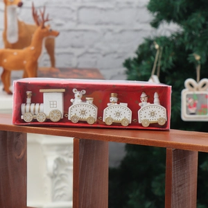 Close-up of white wooden Christmas train with bear and snowman in a red gift box