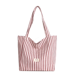 Red and white striped canvas tote bag with front pocket and shoulder straps