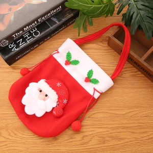 Gros plan du sac cadeau Père Noël en velours avec cordons sur une table en bois