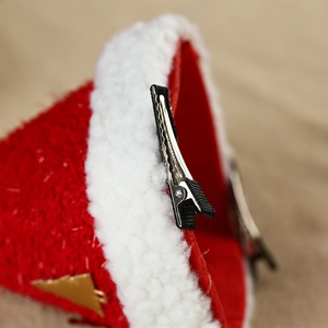 Vue détaillée d'une pince à cheveux bonnet de Noël en velours rouge avec clip crocodile solide