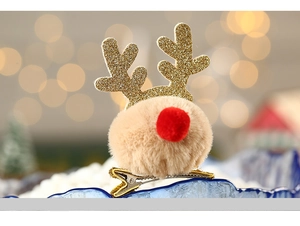 Detail showing a cute reindeer hair clip with brown pompom and golden antlers decoration