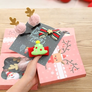 Detail of Christmas hair clips set featuring pink antlers and embroidered tree on card