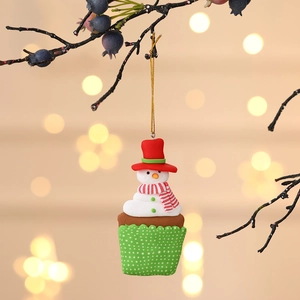 Festive snowman cupcake Christmas ornament hanging on a tree with a gold string