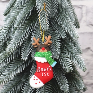 Close-up of Baby's 1st Christmas reindeer ornament hanging on a frosted pine tree
