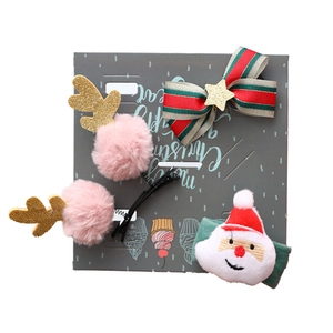 Christmas hair accessory set with reindeer antlers, bow clip, and Santa Claus plush