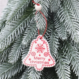 Detailed view of a white wooden bell ornament with red Merry Christmas print and snowflakes