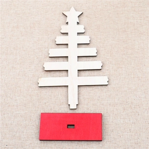 Detail view of a DIY mini wooden Christmas tree with a star top and a red base stand