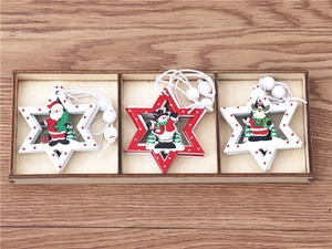 Macro shot of three wooden Christmas star ornaments with Santa, snowman and elk in a wooden tray