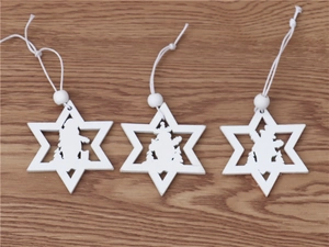 Detail of wooden star Christmas ornaments with laser-cut Santa, snowman and deer motifs