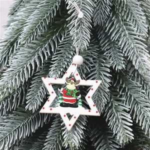 Macro view of a star-shaped Christmas ornament with a wooden reindeer charm on pine branches