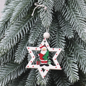 Macro detail of wooden star ornament with painted Santa figure on a Christmas tree