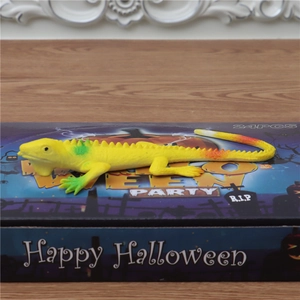 Macro-opname van een realistische gele speelgoedhagedis voor Halloween-feestdecoratie