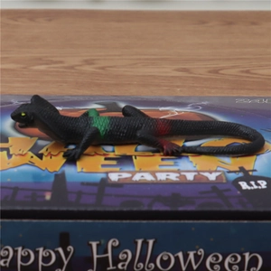 Detailopname van een realistische speelgoedhagedis op een Halloween cadeauverpakking