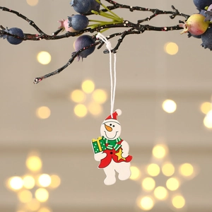 Gros plan d'un bonhomme de neige en bois coloré avec chapeau rouge suspendu à une branche