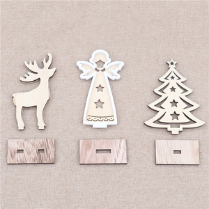 Detailed view of laser-cut wooden Christmas deer, angel, and tree ornaments on fabric