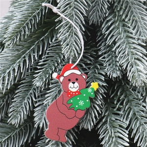 Détail d'une décoration de Noël en bois en forme d'ours suspendue à une branche de sapin