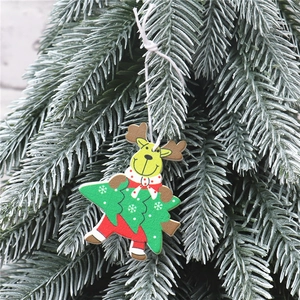 Détail d'un pendentif de Noël en bois avec renne et sapin vert sur une branche enneigée