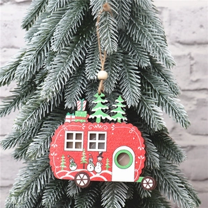 Detail of red wooden caravan ornament with snowman and festive tree on pine branch